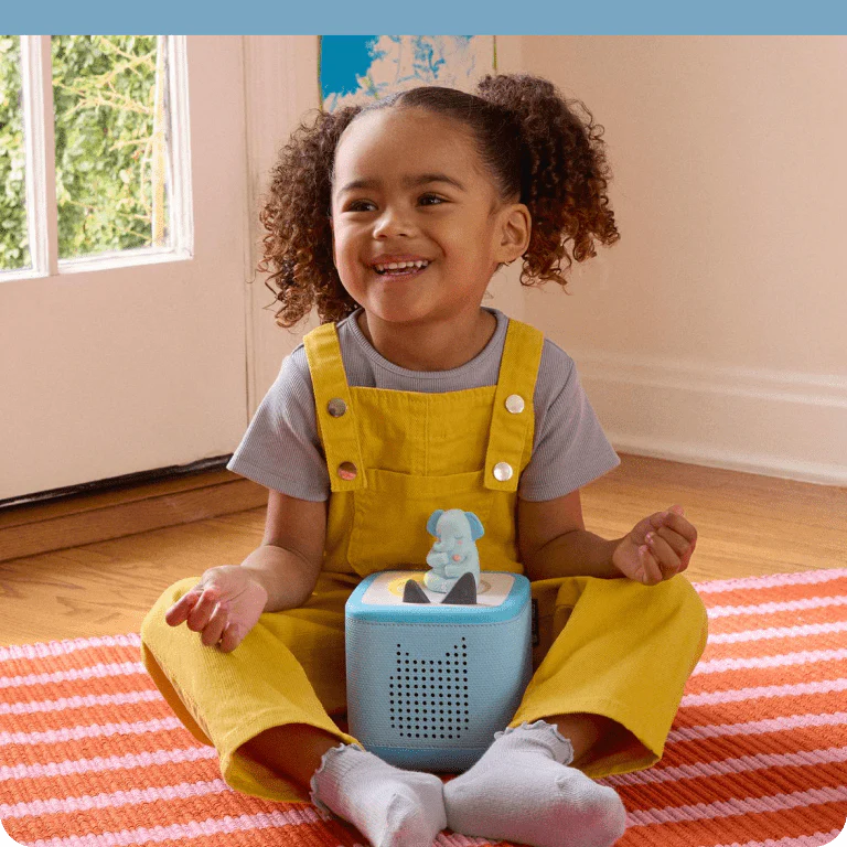 Child sitting and listening to Greta the Elephant Tonie on a blue Toniebox 2